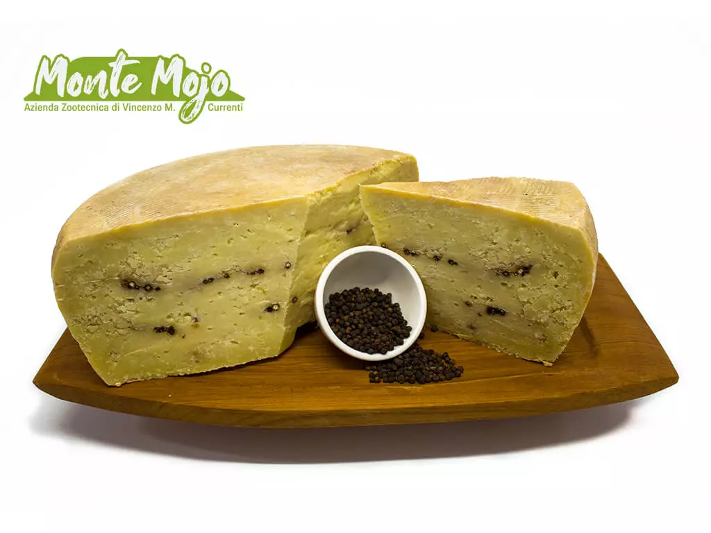 Formaggio Monte Mojo al pepe nero, tagliato, su tagliere.