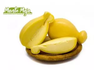 Formaggi caciocavallo a pera, tagliati, su tagliere.